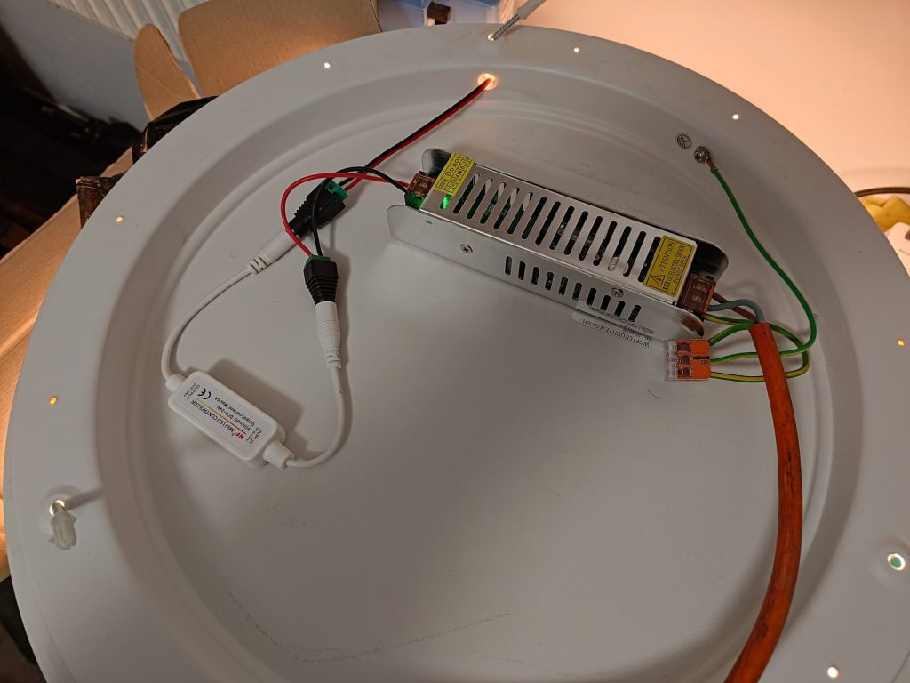 Wnętrze lampy po przeróbce: zasilacz 24 V, miniaturowy sterownik LED RF i złączki WAGO